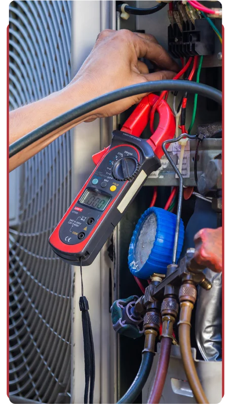 NATE-certified J&G Heating & Air Conditioning technician performing preventive maintenance on an HVAC system